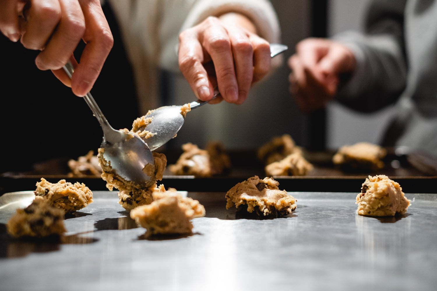 person measuring out baked goods while baking