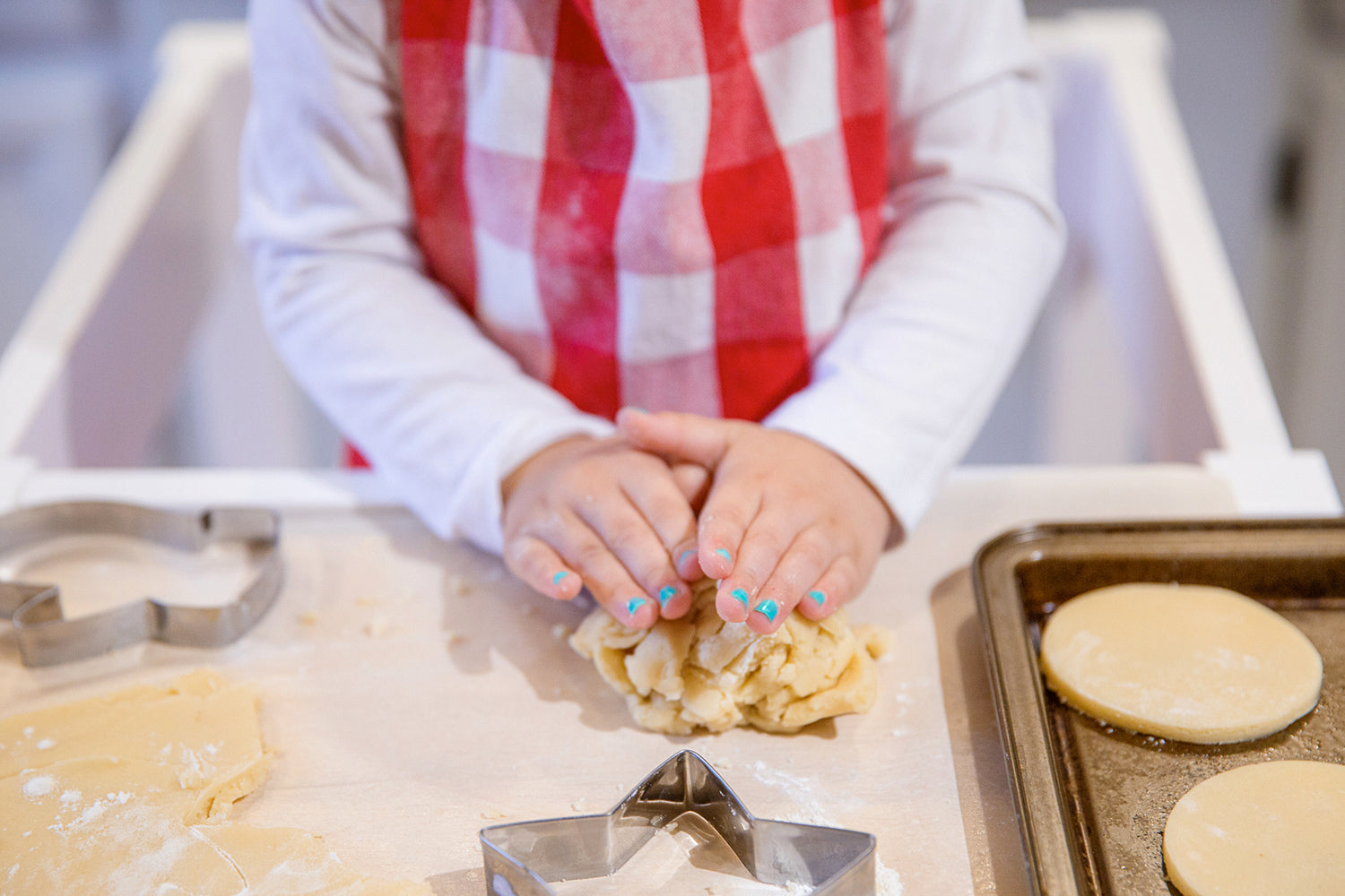 small child rolling baking dough